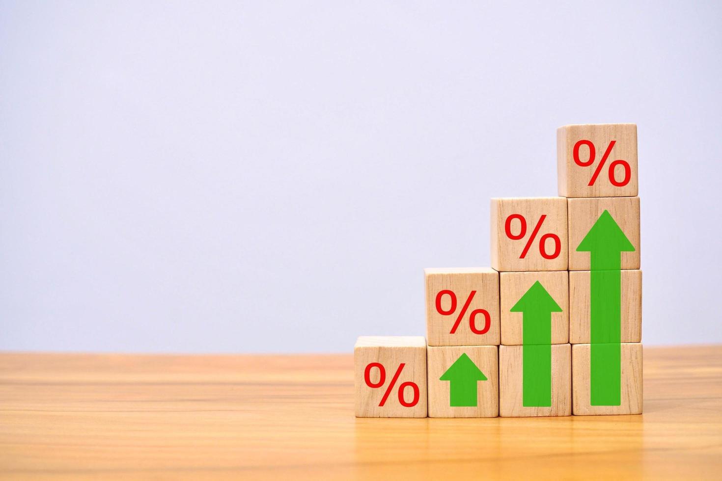 Finance and Mortgage Interest Rate Ideas Wooden cube block above with percentage symbol and direction arrow. photo