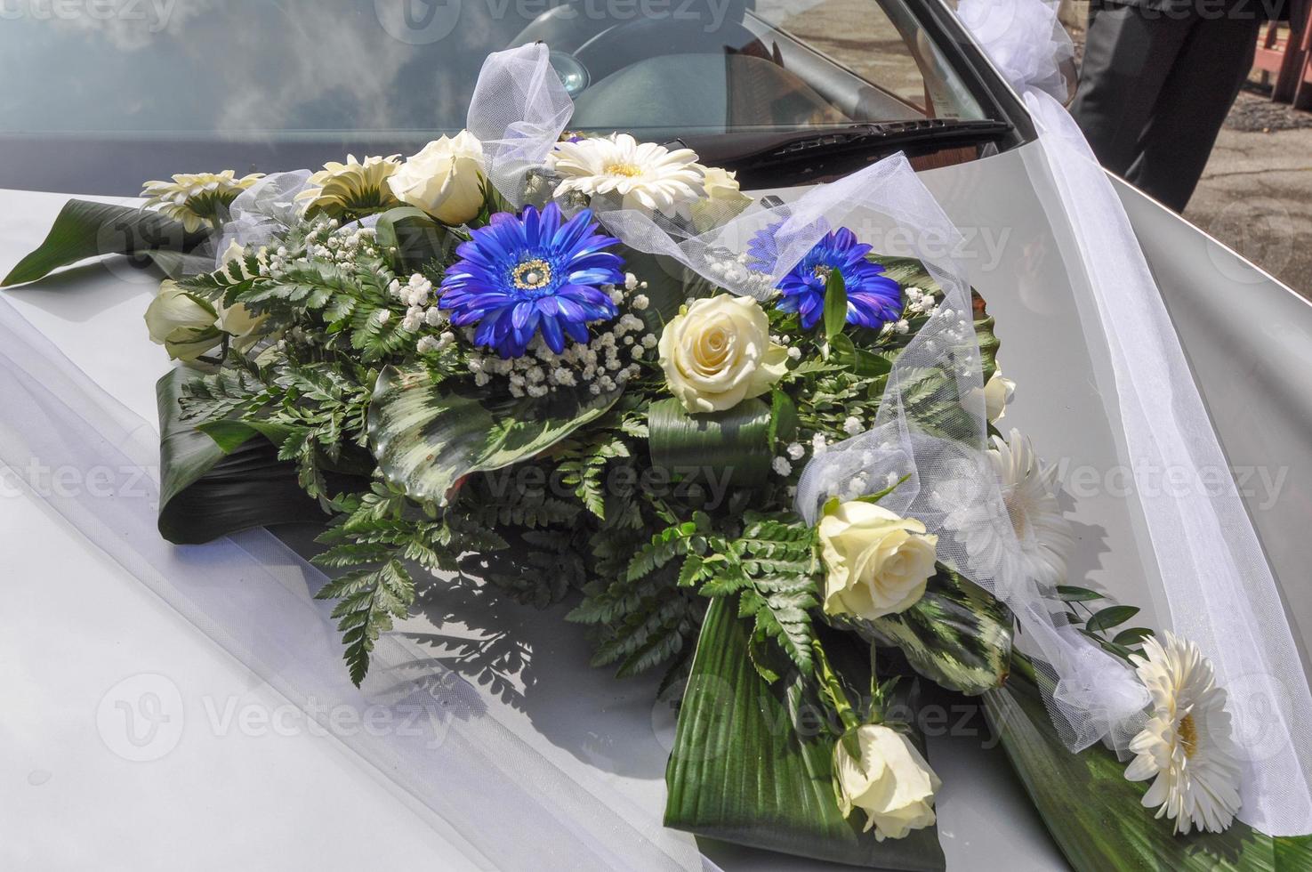 Flowers bouquet on a car at wedding ceremony photo