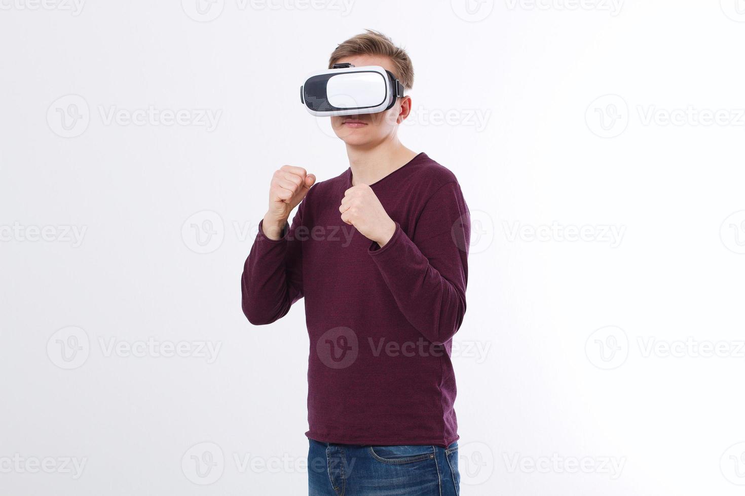 Young an wearing virtual reality goggles isolated on white background. VR glasses technology headset and boxing game. Copy space and mock up photo