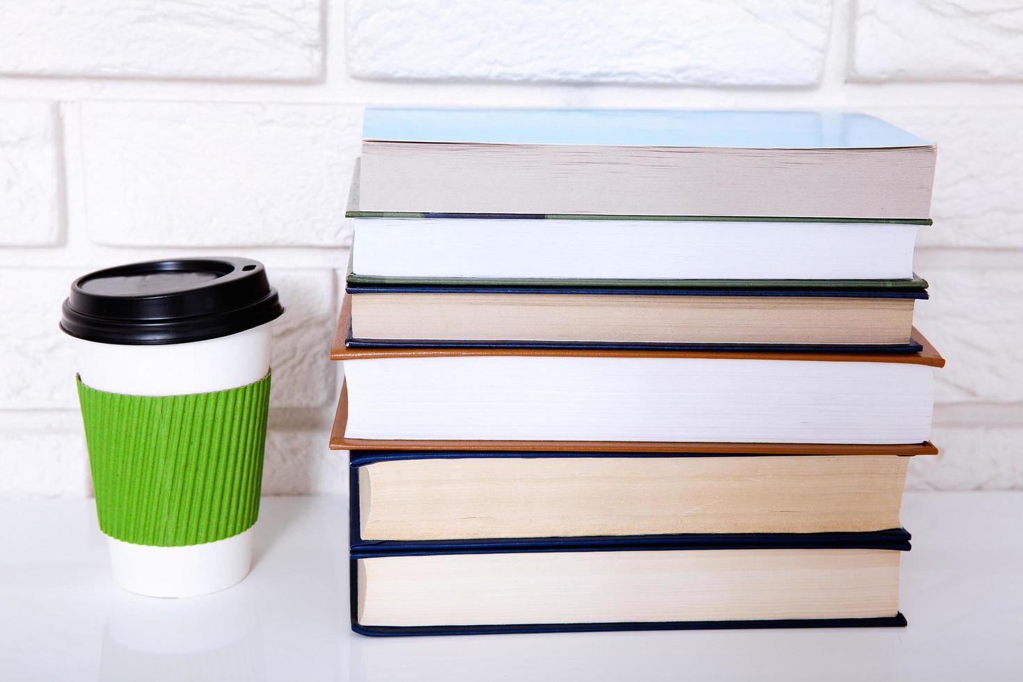 Stack of books and a cup of coffee in the office. Copy space and selective focus photo