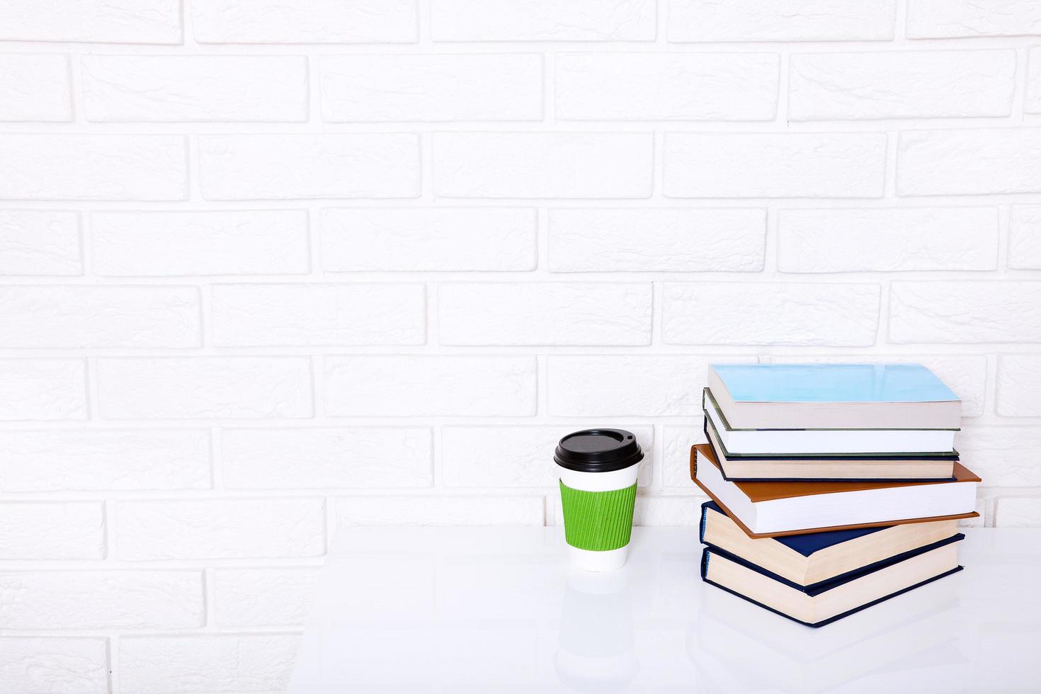 Education literature. Cup of coffee and books on the table in a class. Top view and copy space. Selective focus photo