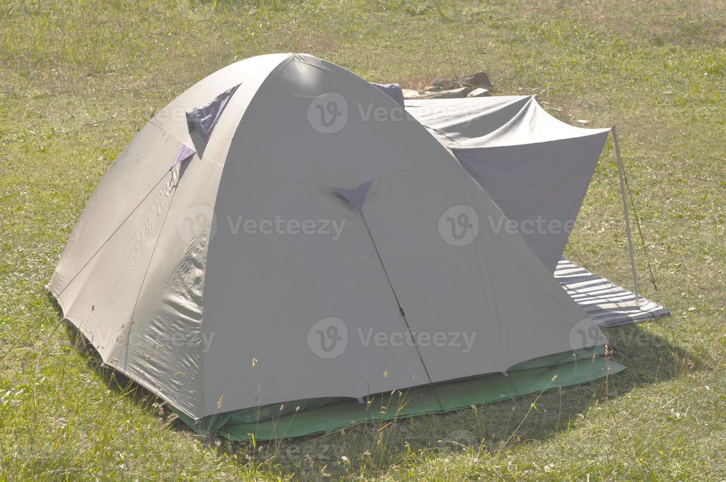A fabric camping tent shelter in a field photo