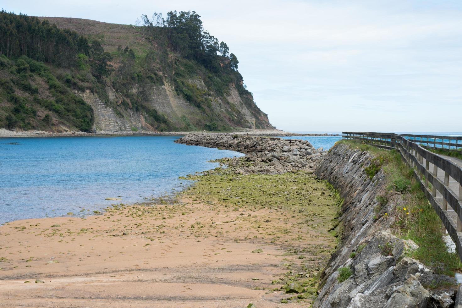 Beautiful beach with no people at El Puntal, Asturias. Calm water. photo