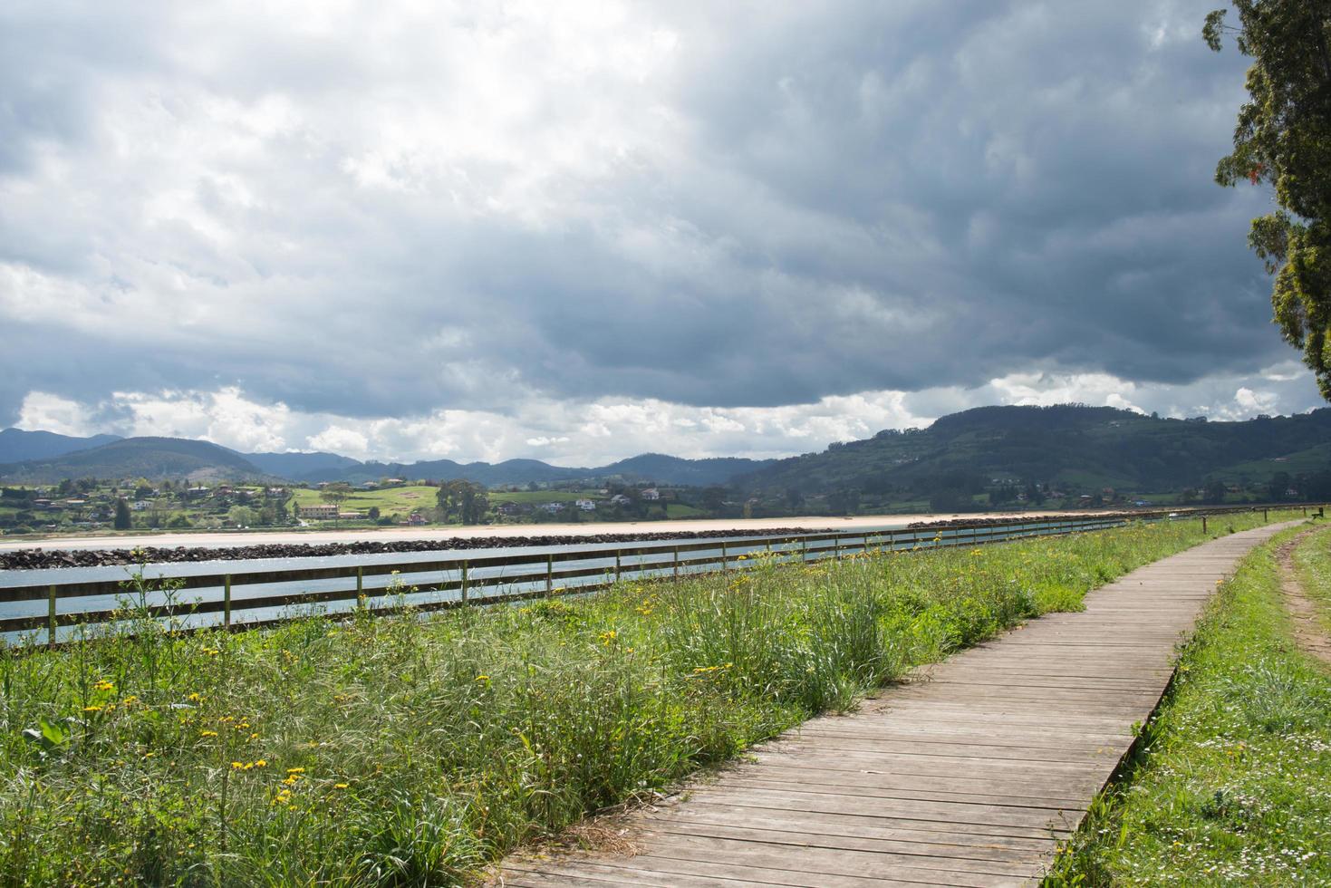 hermoso sendero para caminar sin gente a lo largo del río en el puntal, asturias. nadie. nublado. foto