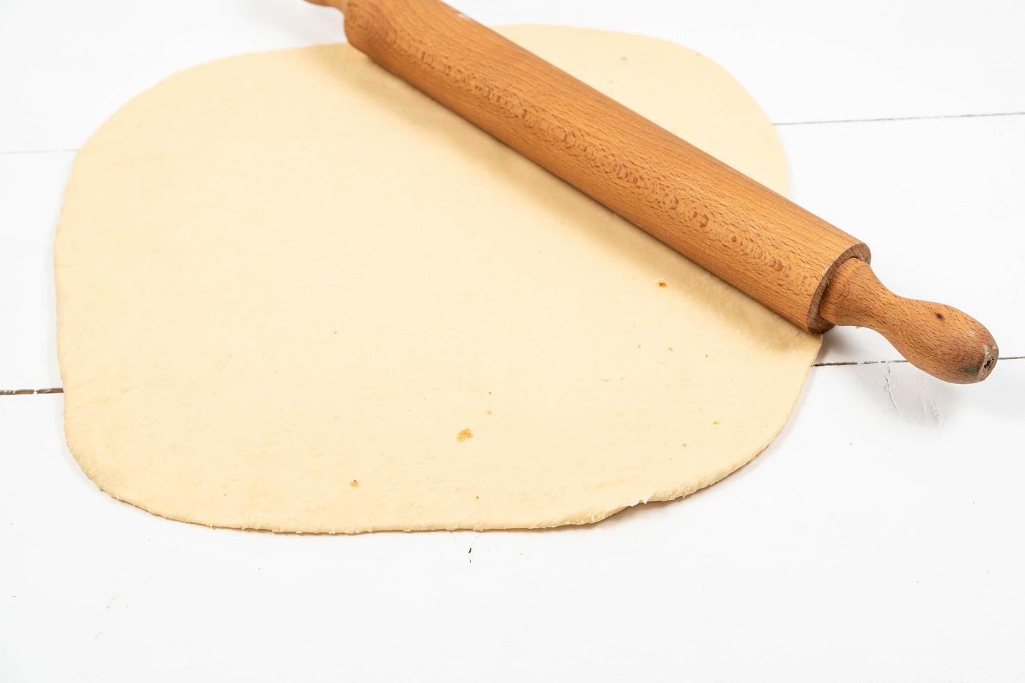 Fresh raw Dough with wooden Rolling Pin photo