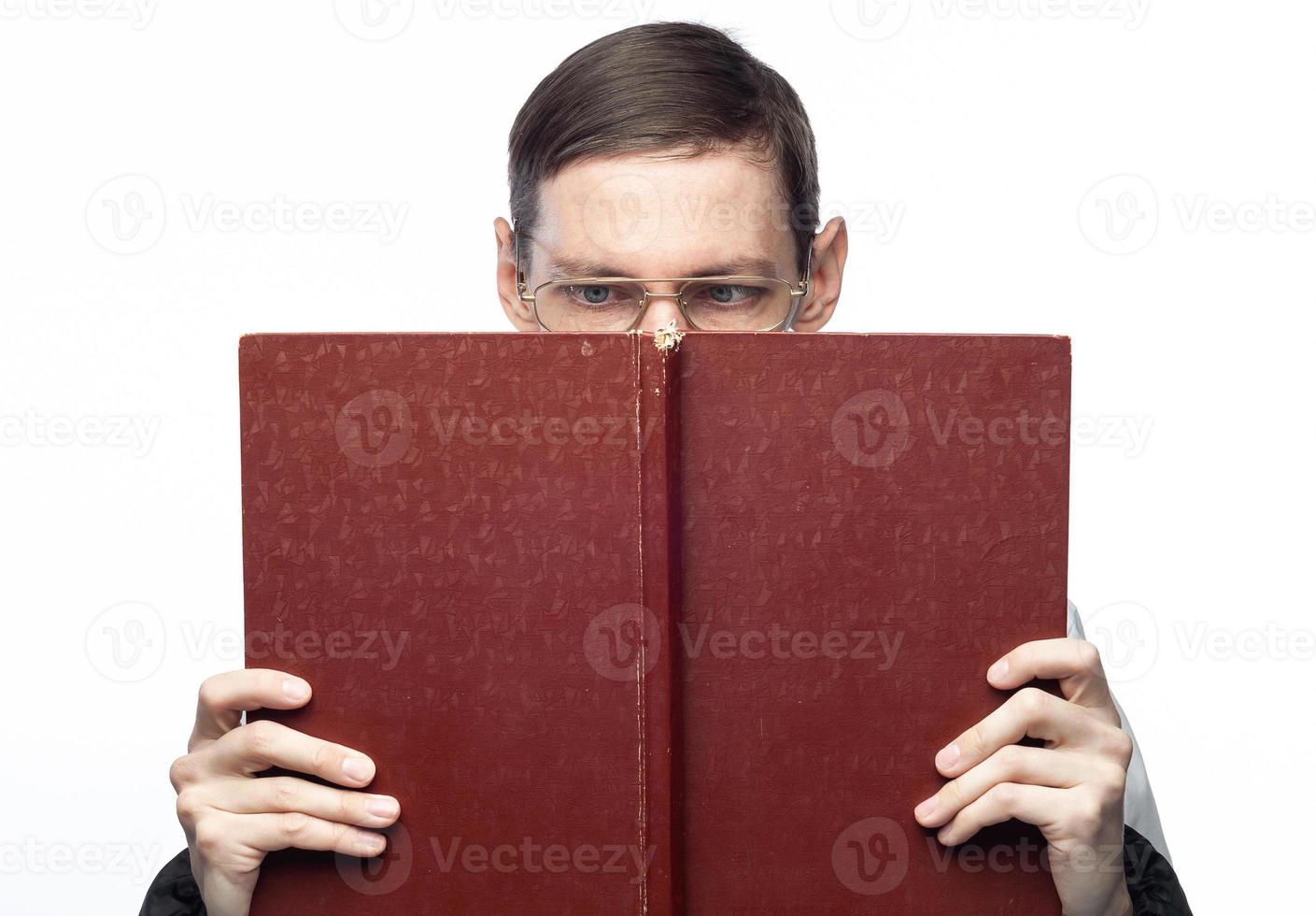 The man's face is covered by a large red notebook, on an isolated background photo