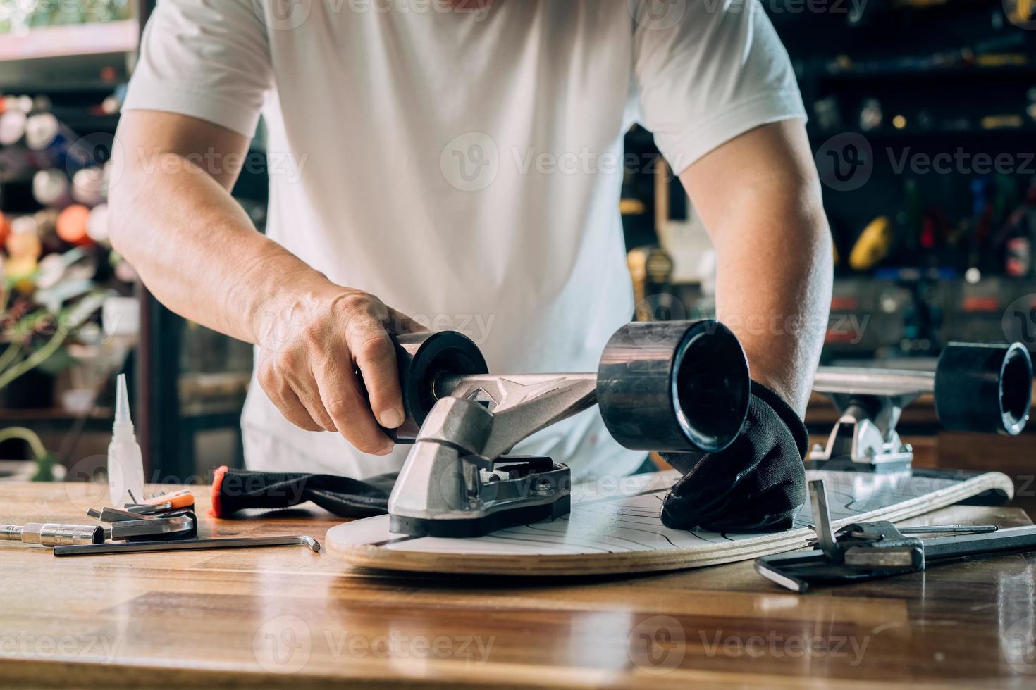 man repairing wheel of skateboard in workshop, Skateboard maintenance and repair concept. Selective focus photo