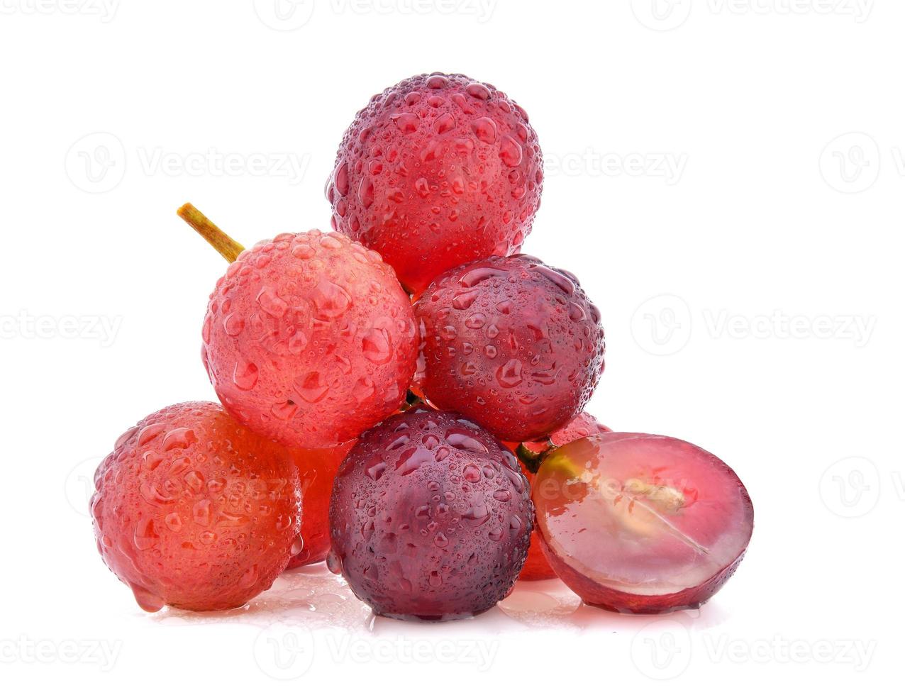 uvas rojas con gota de agua aislado sobre fondo blanco. foto