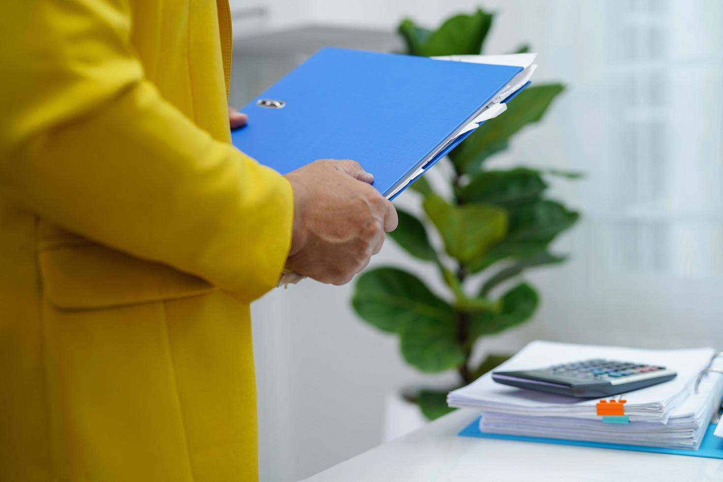 el empresario trabaja y prepara los datos del informe de papeleo para analizar la información en la carpeta de archivos en la oficina. foto