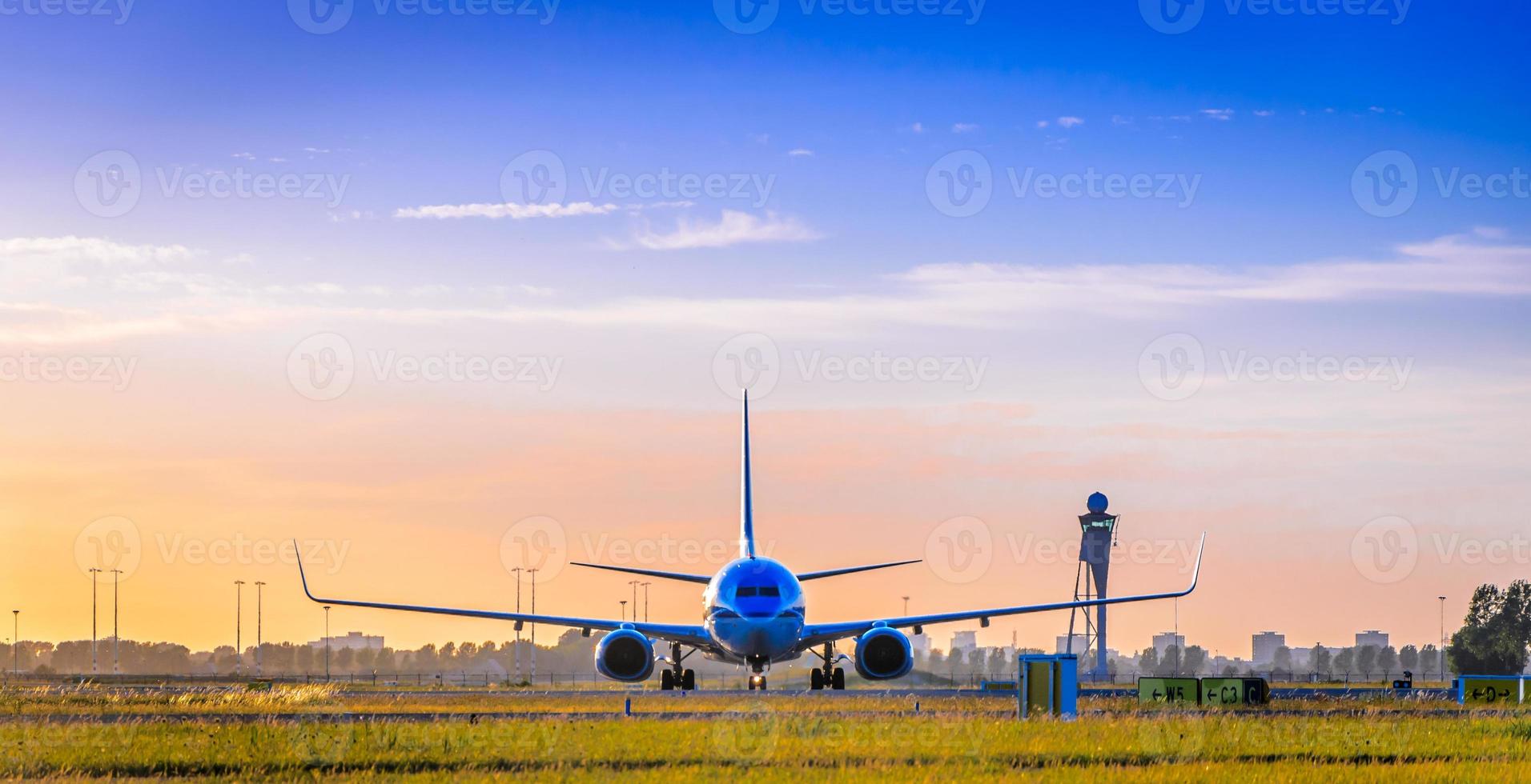Front view of commercial airplane on tarmac at sunset photo