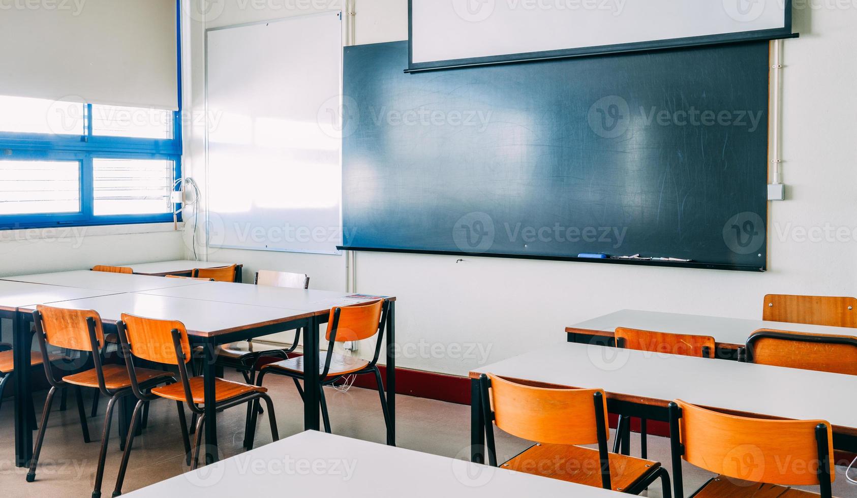 sala de conferencias o aula vacía de la escuela con escritorios y sillas de madera de hierro para estudiar lecciones en la escuela secundaria tailandia, interior de educación secundaria, con pizarra, concepto educativo de tono vintage. foto