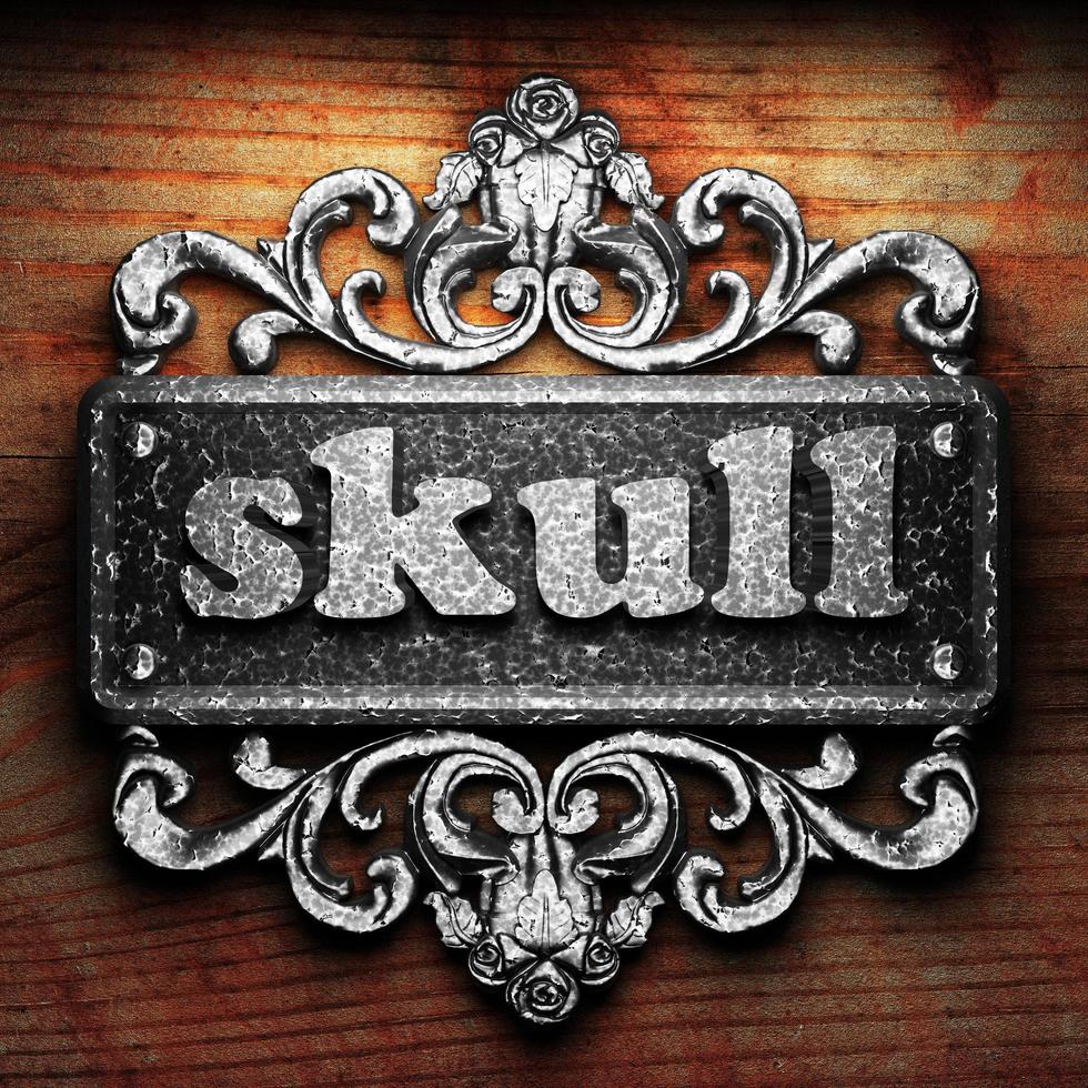 skull word of iron on wooden background photo