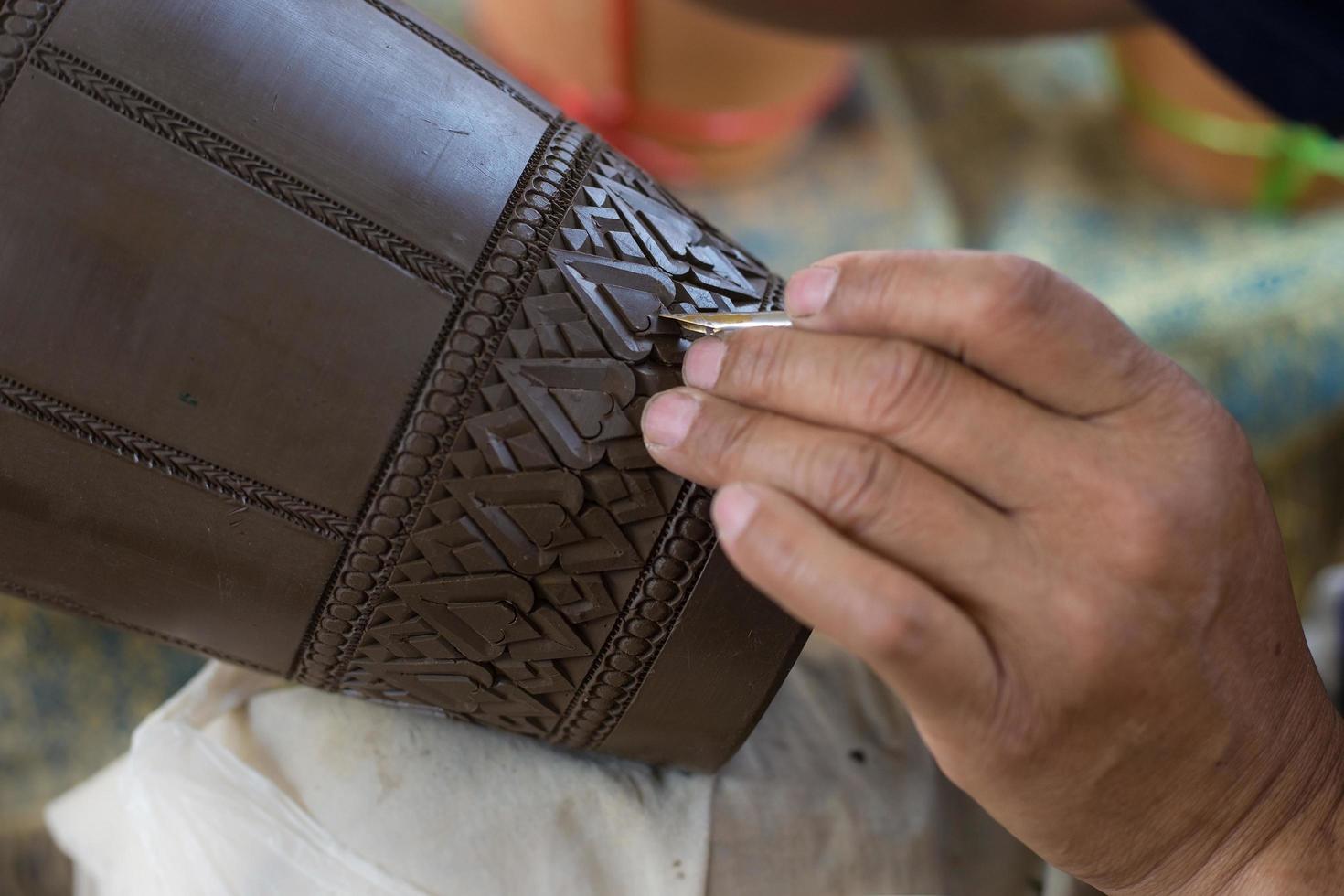 Carved pottery jar is a Thai traditional handcrafted. It is a art on earthenware. photo