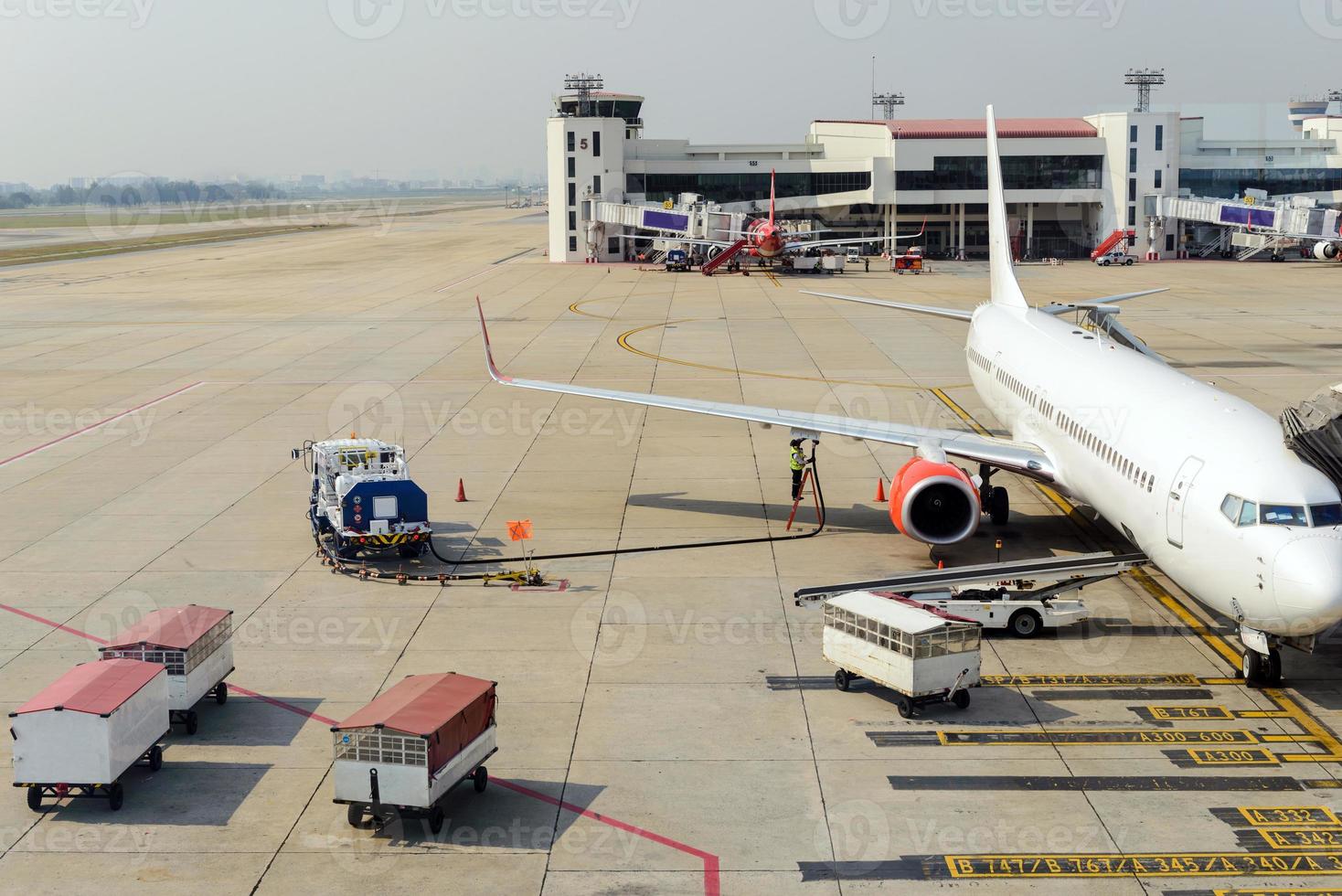 Aircraft worker receiving fuel to the airplane photo