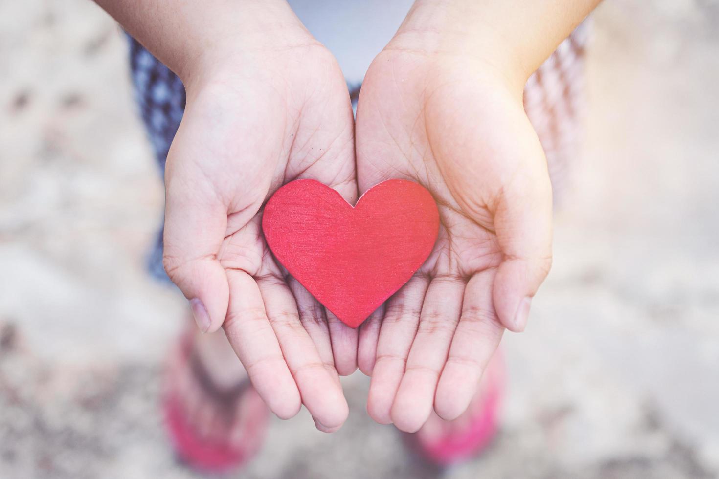 Small kid hands holding heart photo
