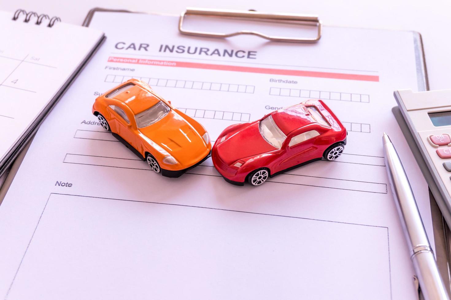 Car insurance form with model and policy document photo