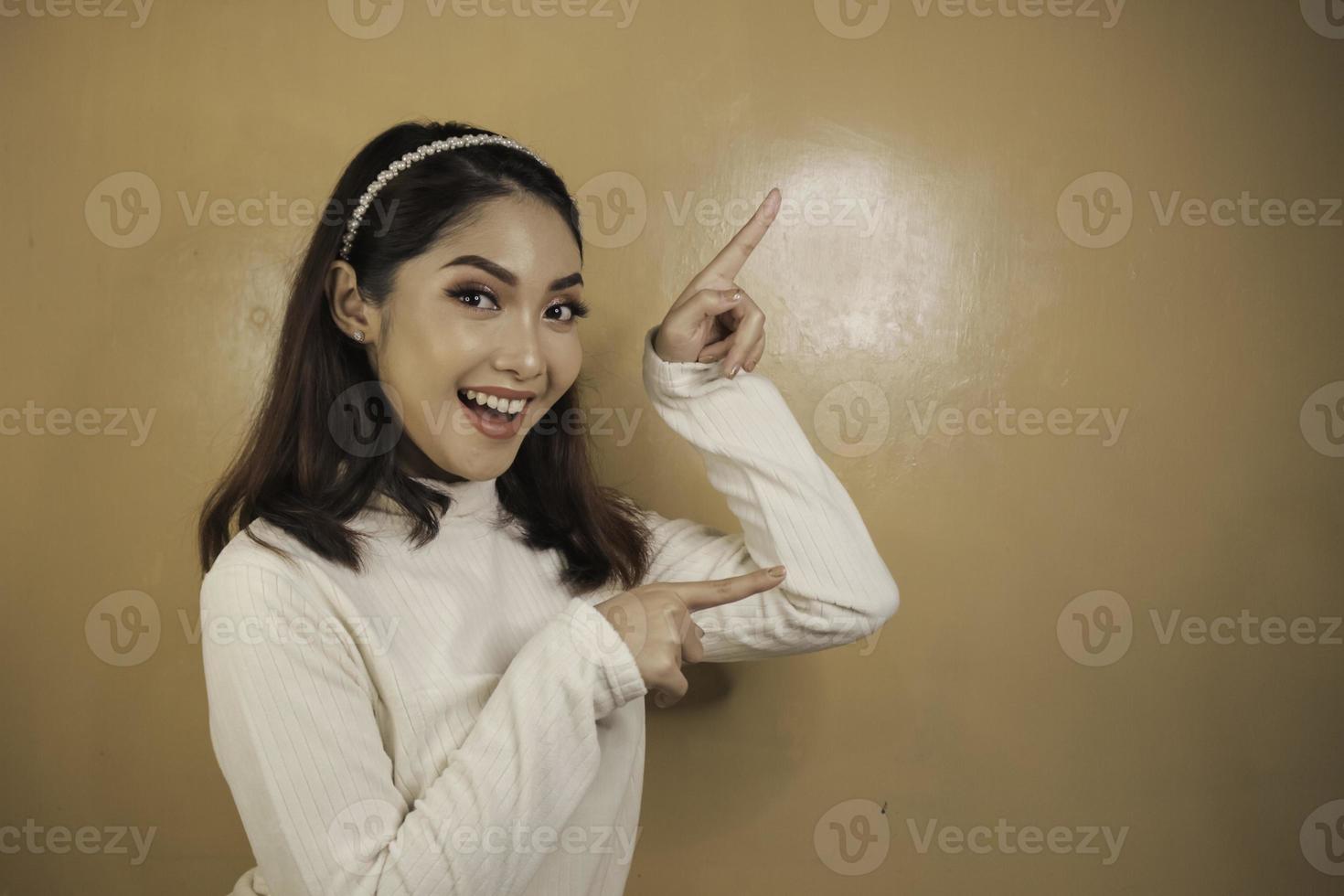 Happy and smile face with smile of young Asian girl with hand point on empty space. photo