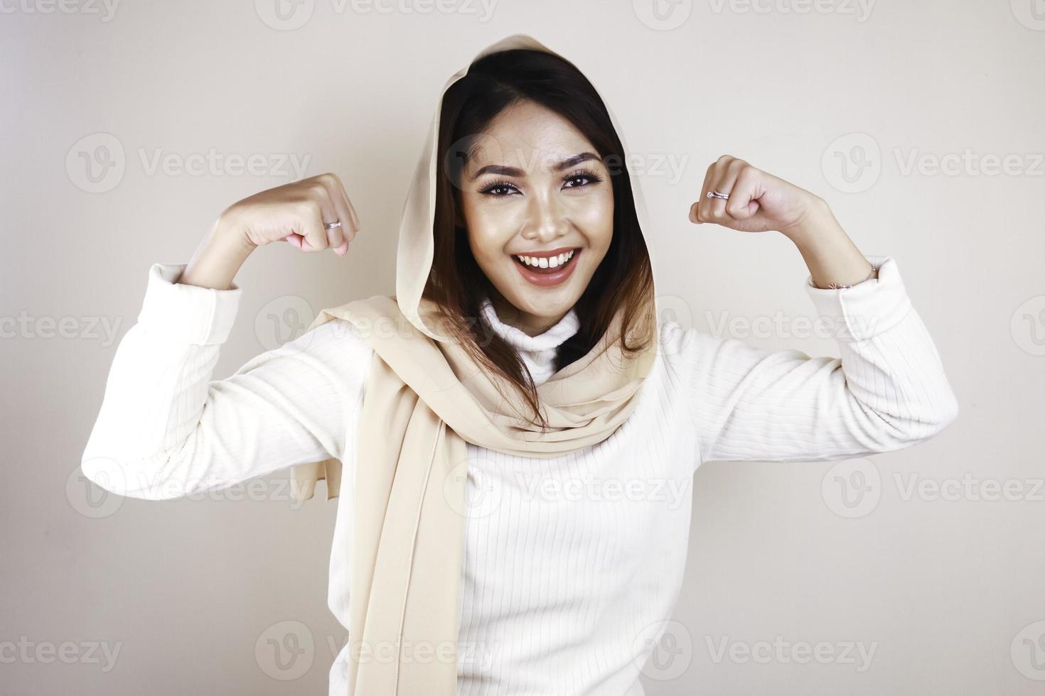 Gorgeous strong young Muslim woman isolated over white background wall showing biceps. photo