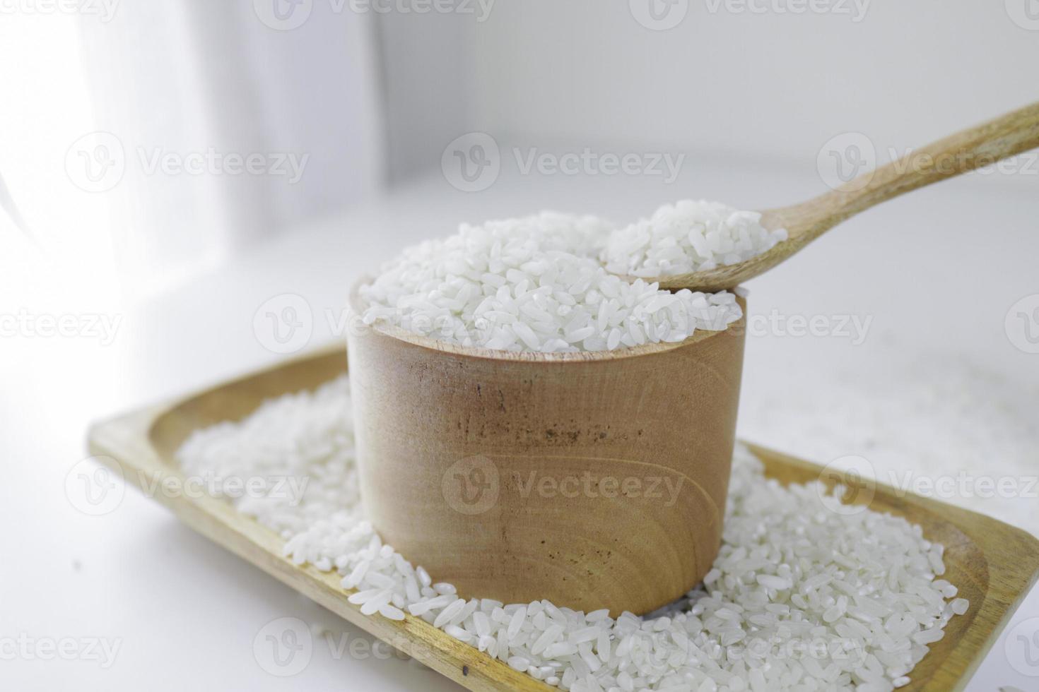 arroz en cuchara de madera y tazón de madera foto
