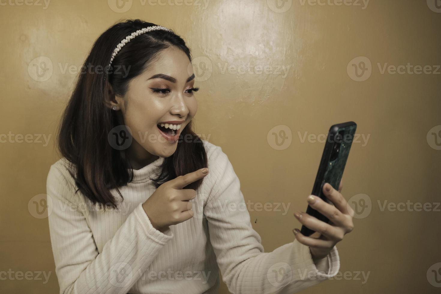 mujeres asiáticas jóvenes felices y sonrientes en el teléfono foto