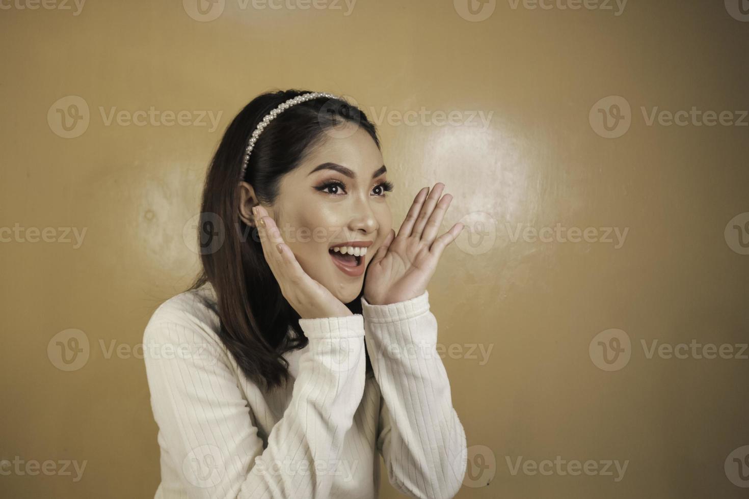 Attractive young Asian female shocked face leaning chin on hand photo