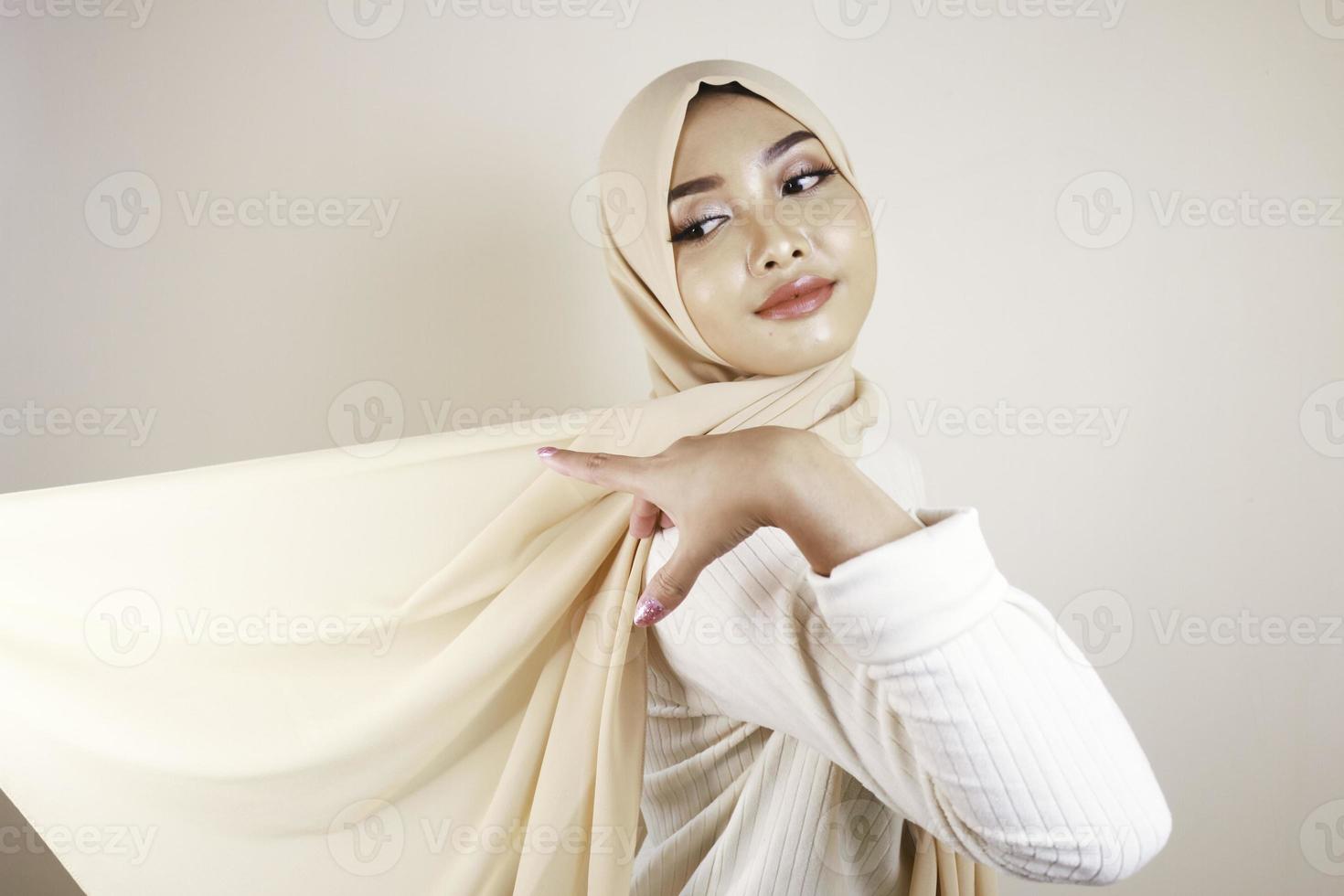 Muslim woman wearing traditional wear and hijab isolated on white background. Hijab is creatively made flying. Idul Fitri and hijab fashion concept. photo