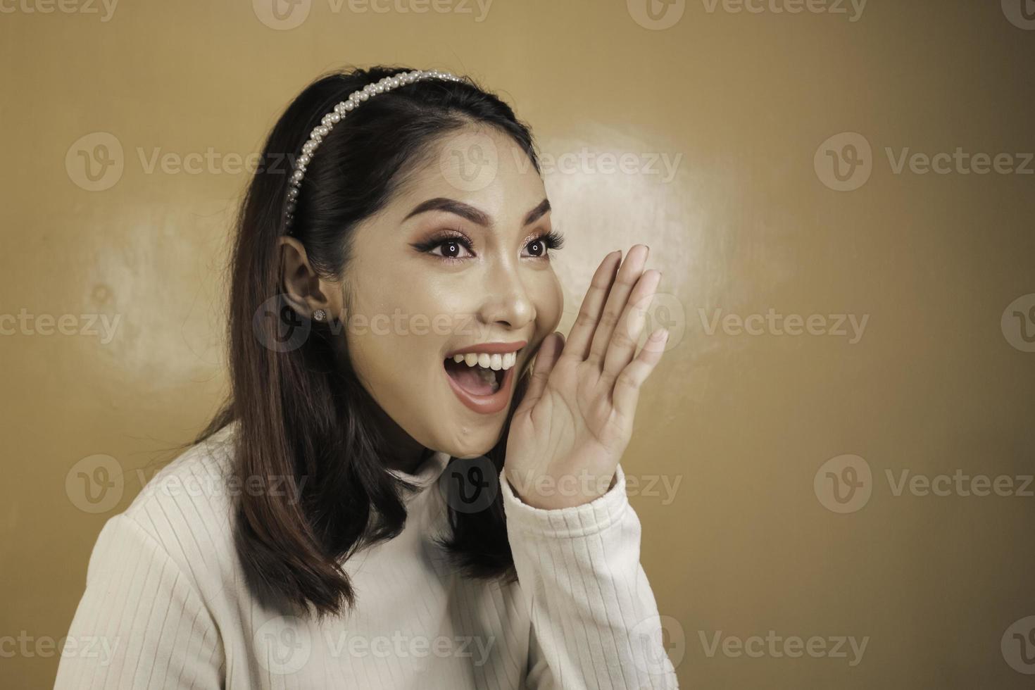Attractive young Asian female shocked face leaning chin on hand photo