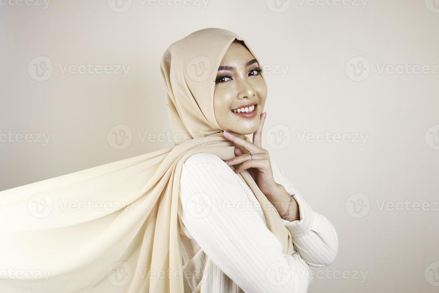 mujer musulmana con ropa tradicional y hiyab aislada de fondo blanco. el hiyab se hace volando de forma creativa. concepto de moda idul fitri e hijab. foto