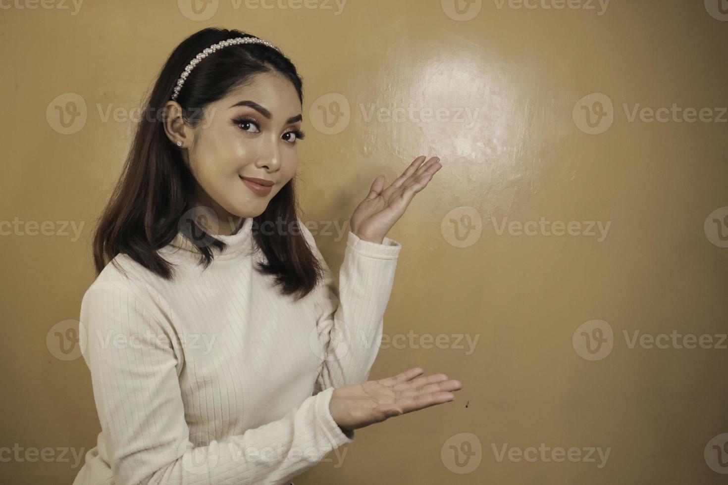 Happy and smile face with smile of young Asian girl with hand point on empty space. photo