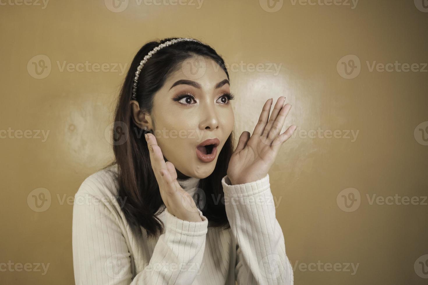 Wow and shocked face of Young Asian woman with open hand gesture. Advertising model concept. photo