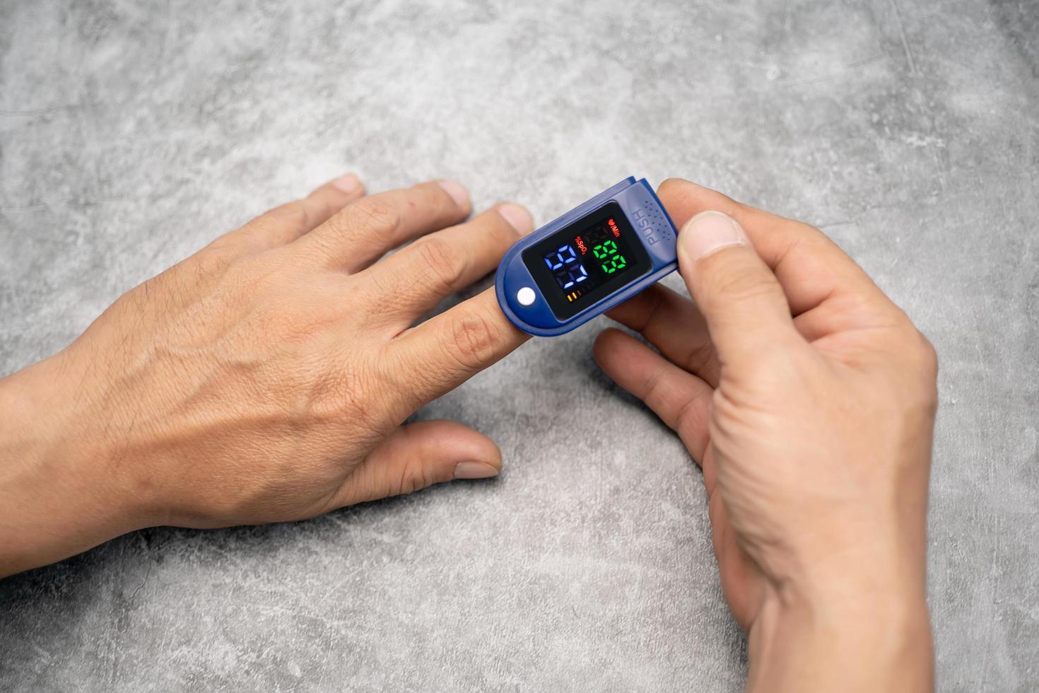 man using pulse oximeter device on finger,Oxygen Saturation Monitor use light pass through the blood in finger measuring amount of oxygen,healthcare concept, photo