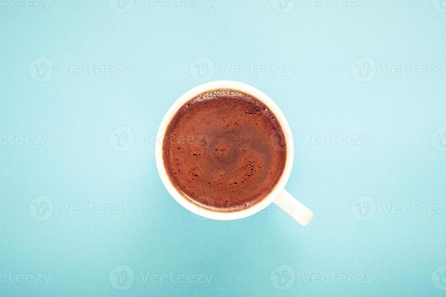 A cup of fresh hot Turkish coffee on blue background. photo