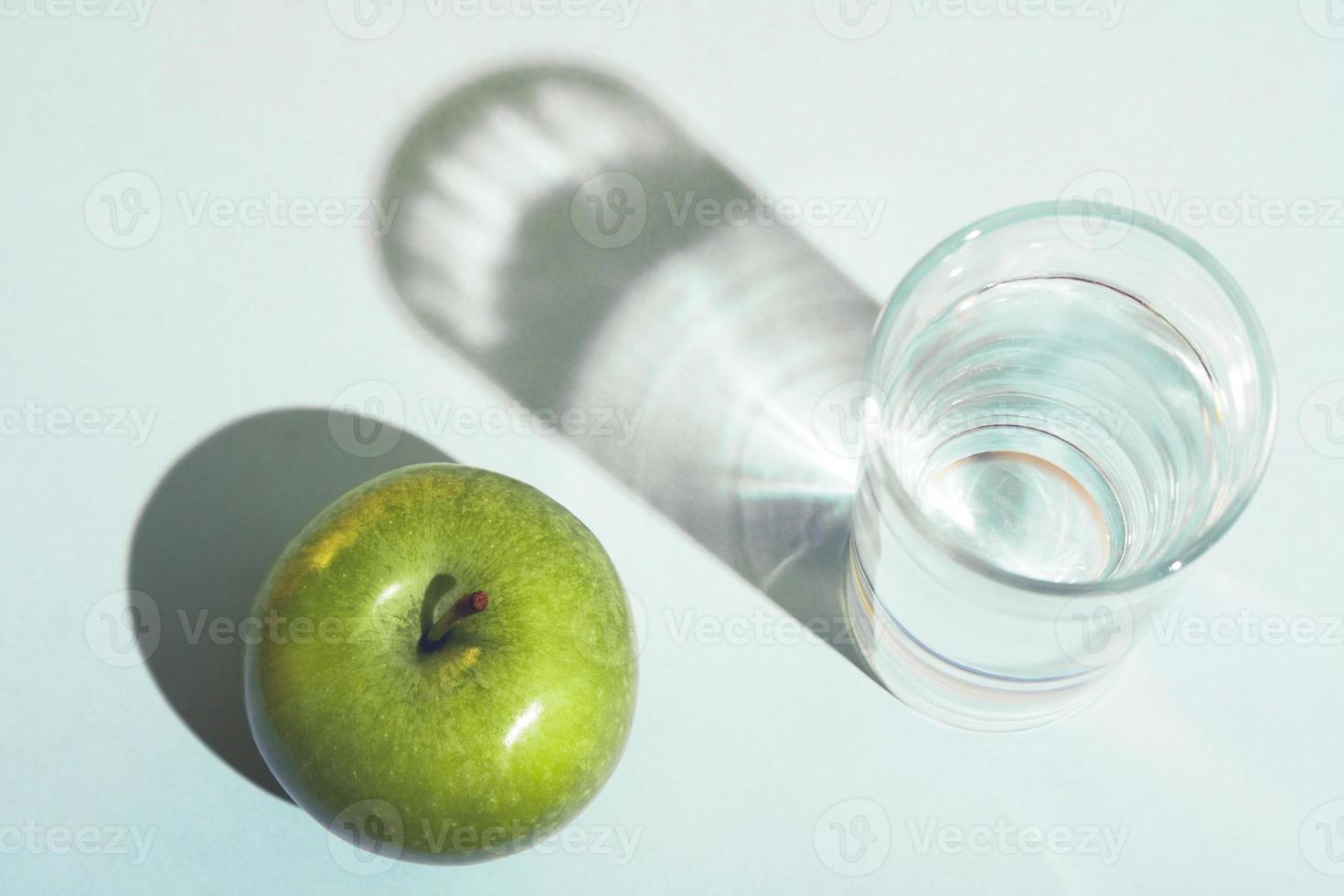 Healthy lifestyle and diet concept with a green apple and a glass of water. photo