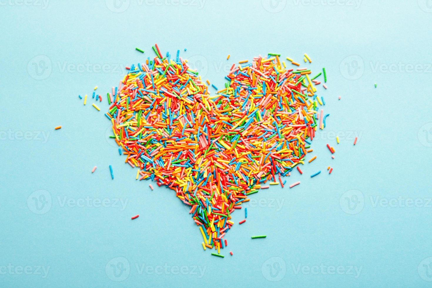 Simple concept flatlay with a heart made of colorful sugar sprinkles. photo