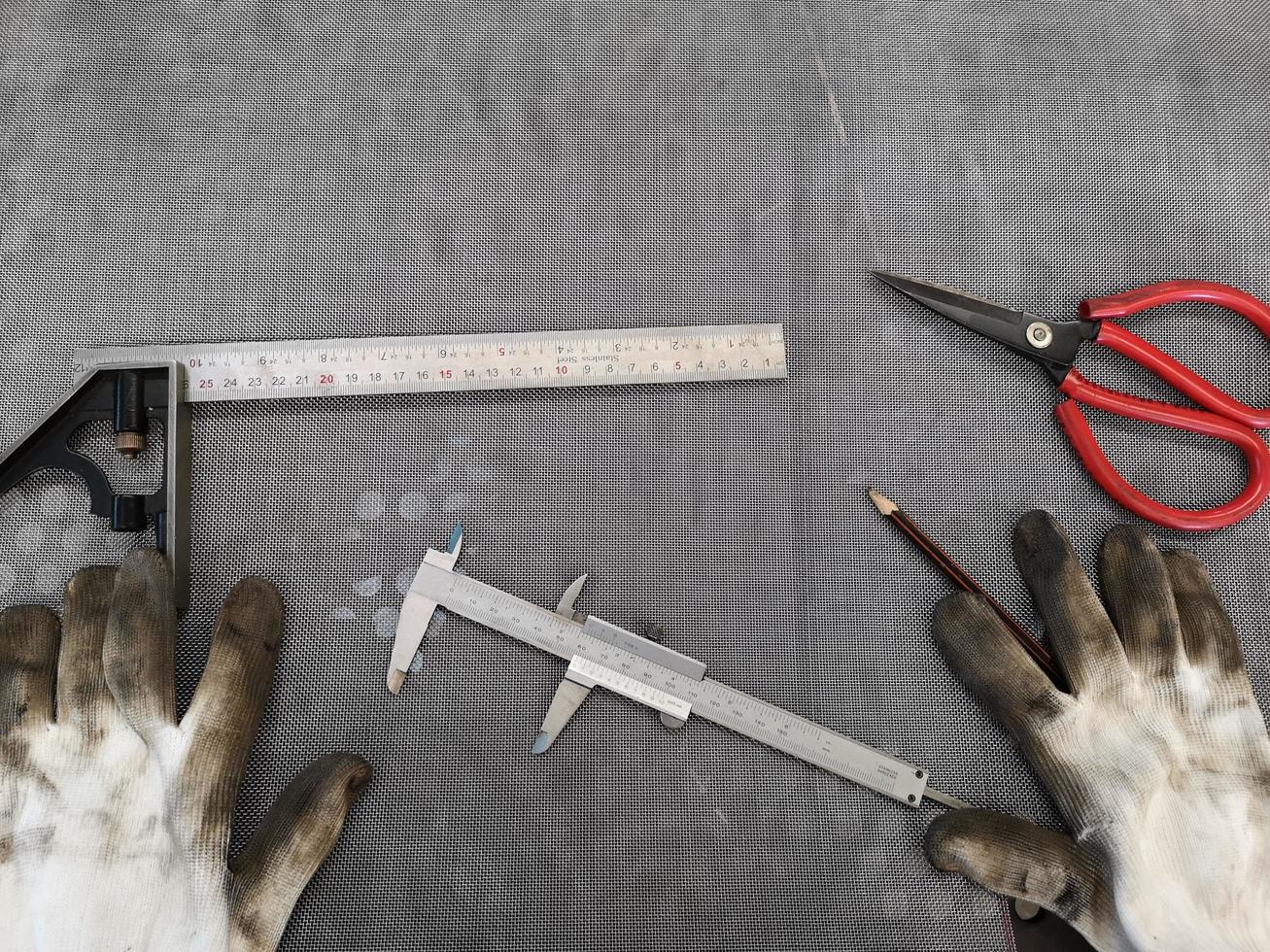 guantes sucios y vernier en taller, equipo mecánico foto