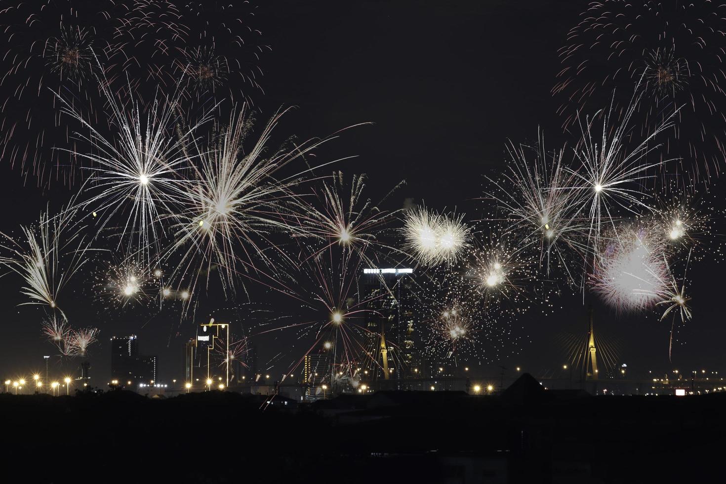 fuegos artificiales con vista de la ciudad de la luz de la noche del paisaje urbano, exhibición de fuegos artificiales de colores sobre el horizonte de la arquitectura del edificio del rascacielos en el centro de la ciudad por la noche foto