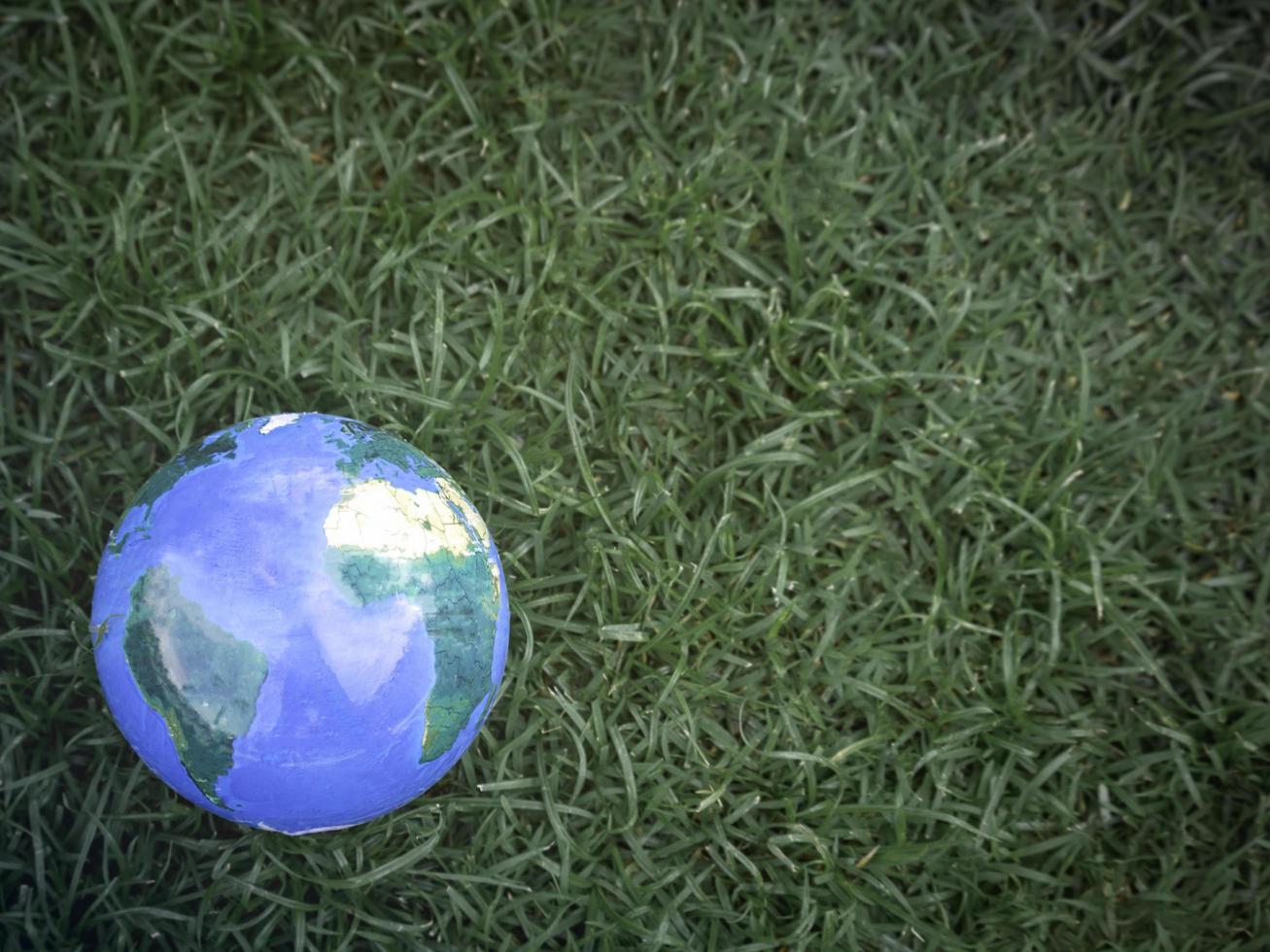 Earth on on green grass, save the world, love and protect our planet, and environmental friendly concept photo