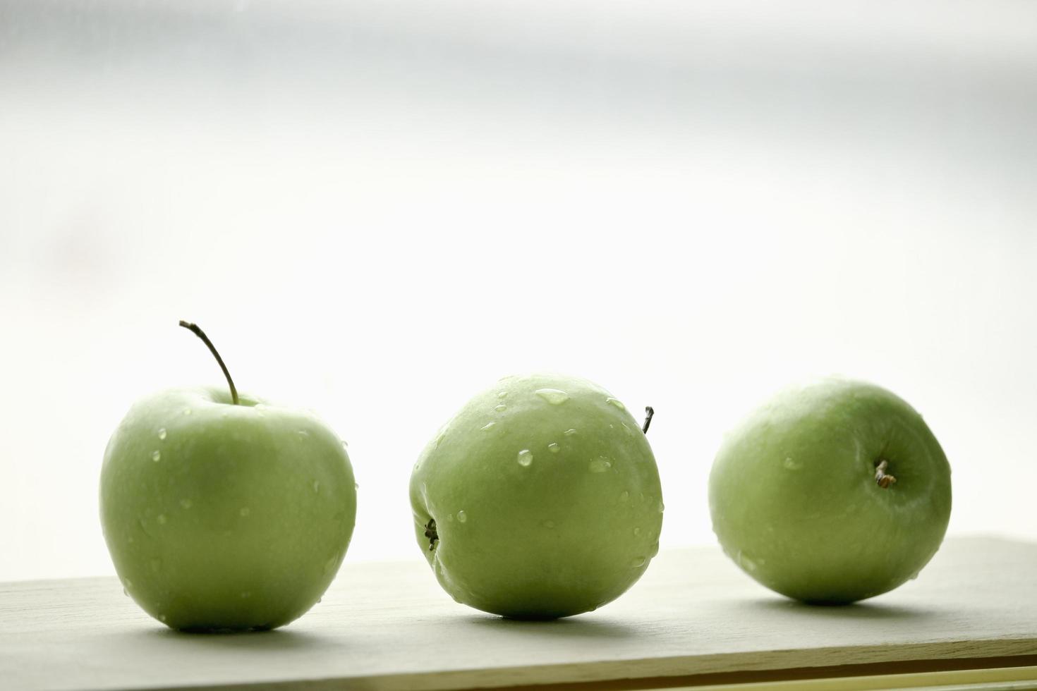 Ripe green apple raw fruit with water drop on wooden table, healthy organic fresh produce photo