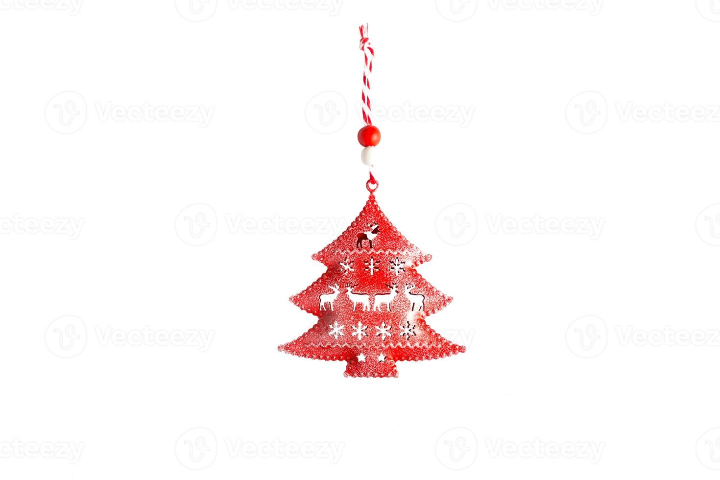 Red toy Christmas tree made of metal with slots in the form of deer and snowflakes and a striped rope on a white background, isolate. Christmas, new year, decoration accessory photo