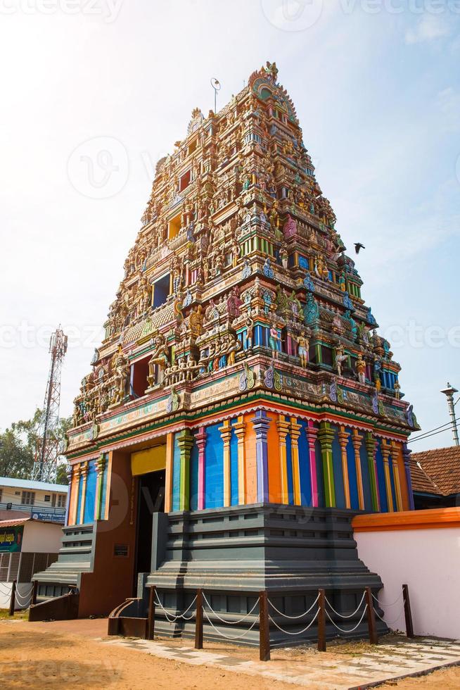 Traditional Hindu temple Kidangamparambu Sree Bhuvaneswari in India in Allapuzha Allepi Kerala. Tall building with colorful figures of Indian mythology and gods, flock of live birds. Tourism, travel photo