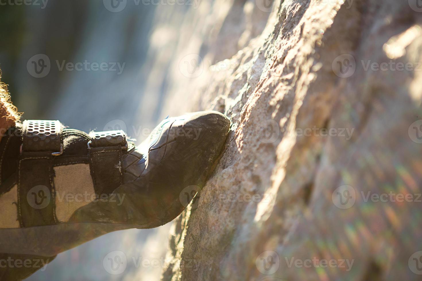 Climbing shoes on the climber's foot rest the toe on the rock. Extreme sports, mountain tourism. Close-up. Copy space. Hairy male leg photo