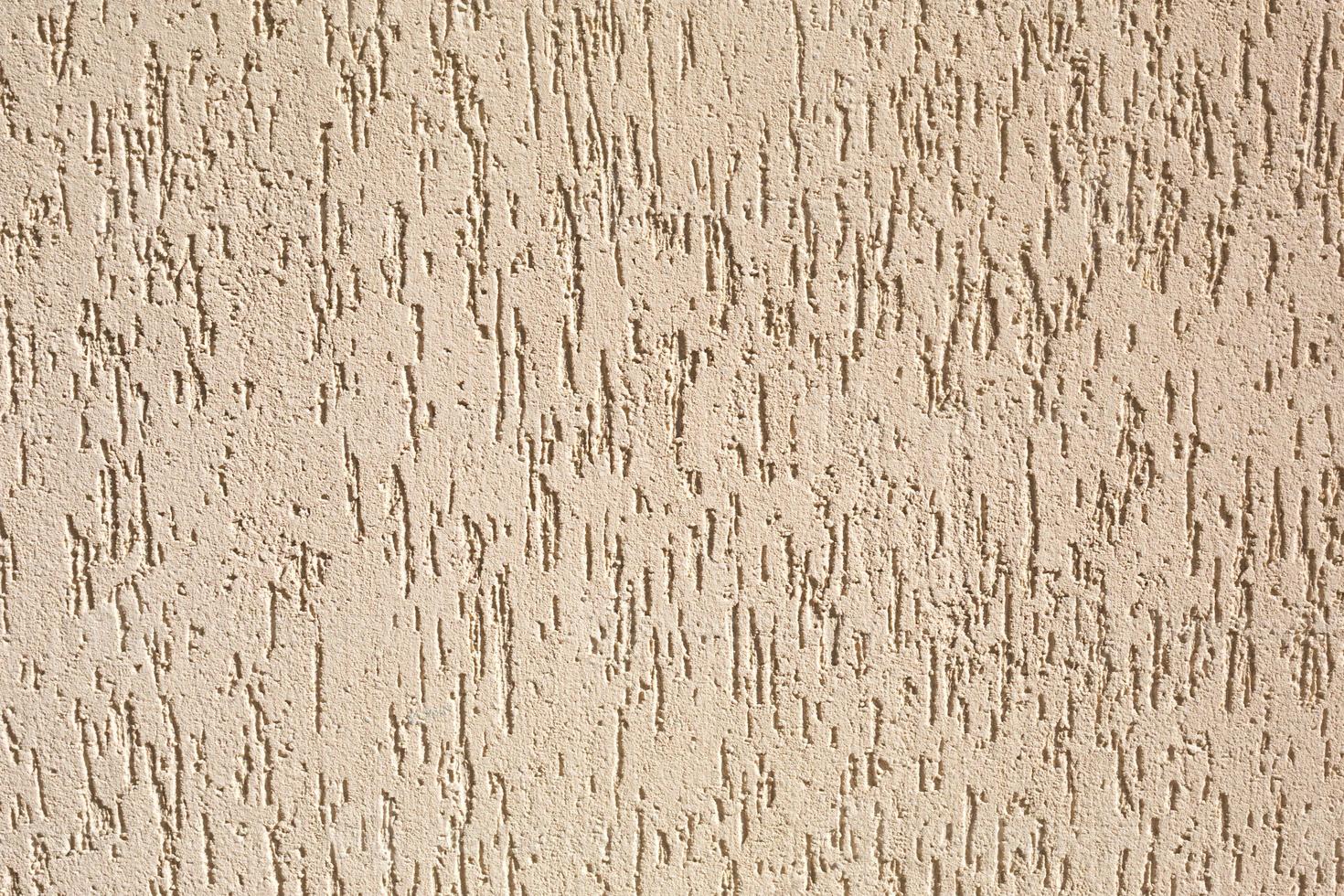 yeso en la pared con un patrón de escarabajo de corteza de color beige y arena. fondo, textura. decoración exterior del edificio, casa. foto