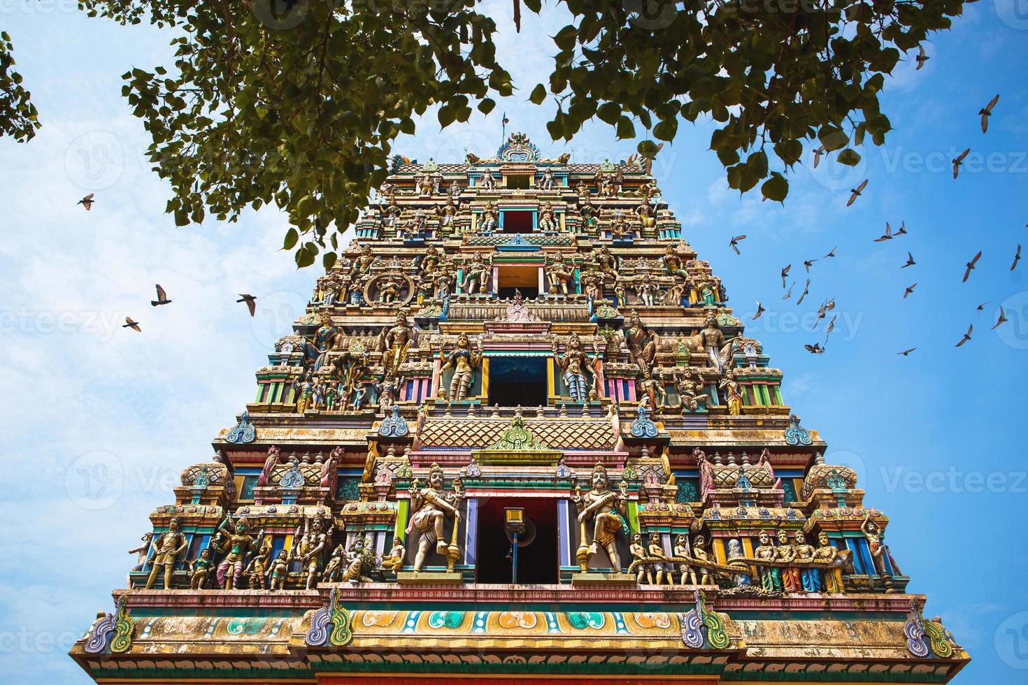 Traditional Hindu temple Kidangamparambu Sree Bhuvaneswari in India in Allapuzha Allepi Kerala. Tall building with colorful figures of Indian mythology and gods, flock of live birds. Tourism, travel photo