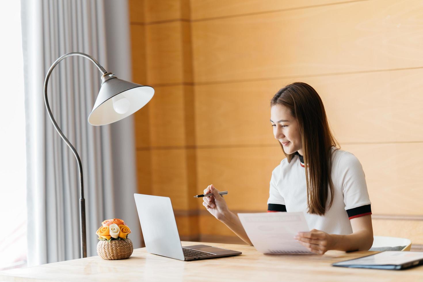 Smiling young woman using laptop, sitting on couch at home, beautiful girl shopping or chatting online in social network, having fun, watching movie, freelancer working on computer project photo