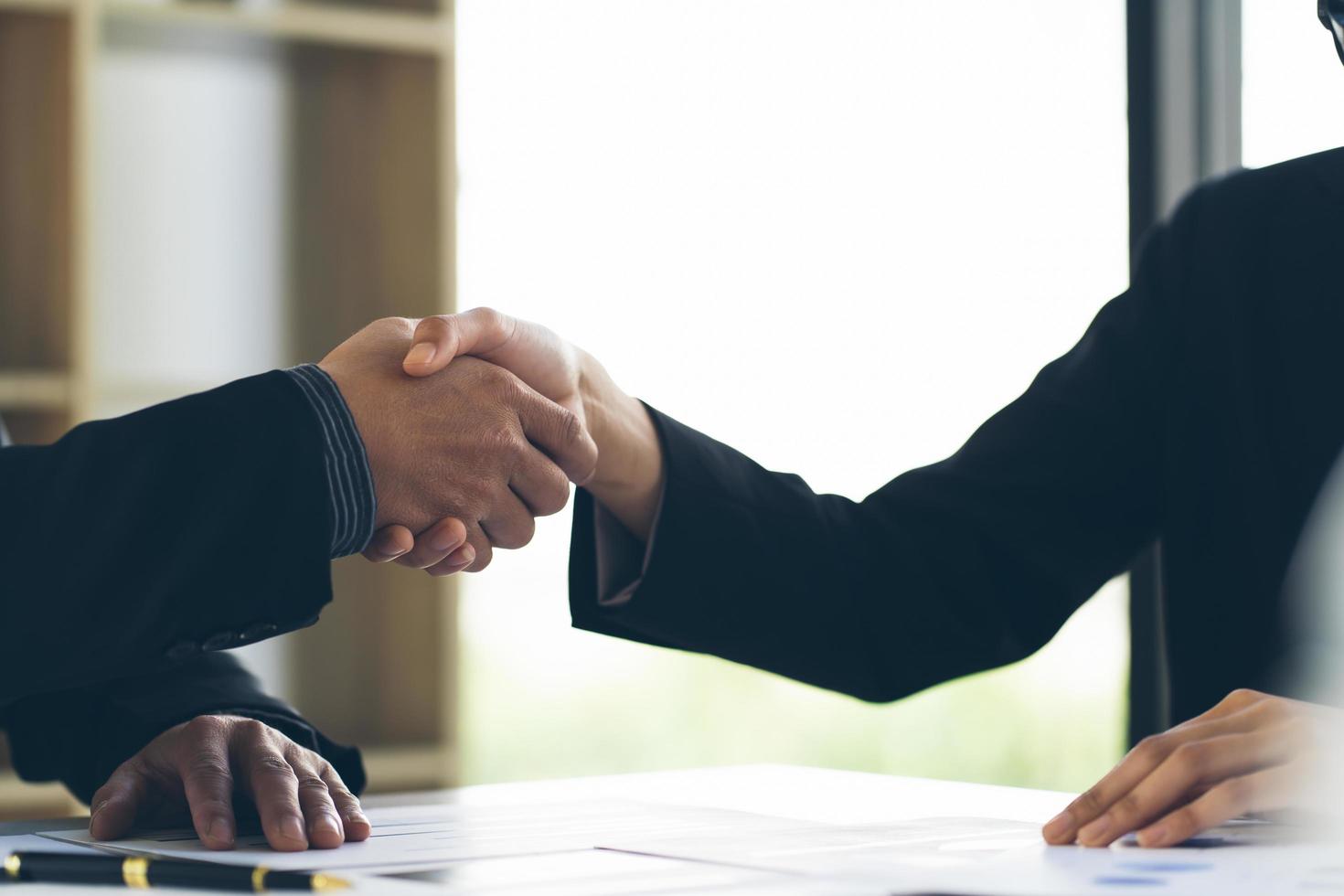 Close up view of business partnership handshake.Concept two businessman handshaking process.Successful deal after great meeting.Horizontal,flare effect, blurred background. photo