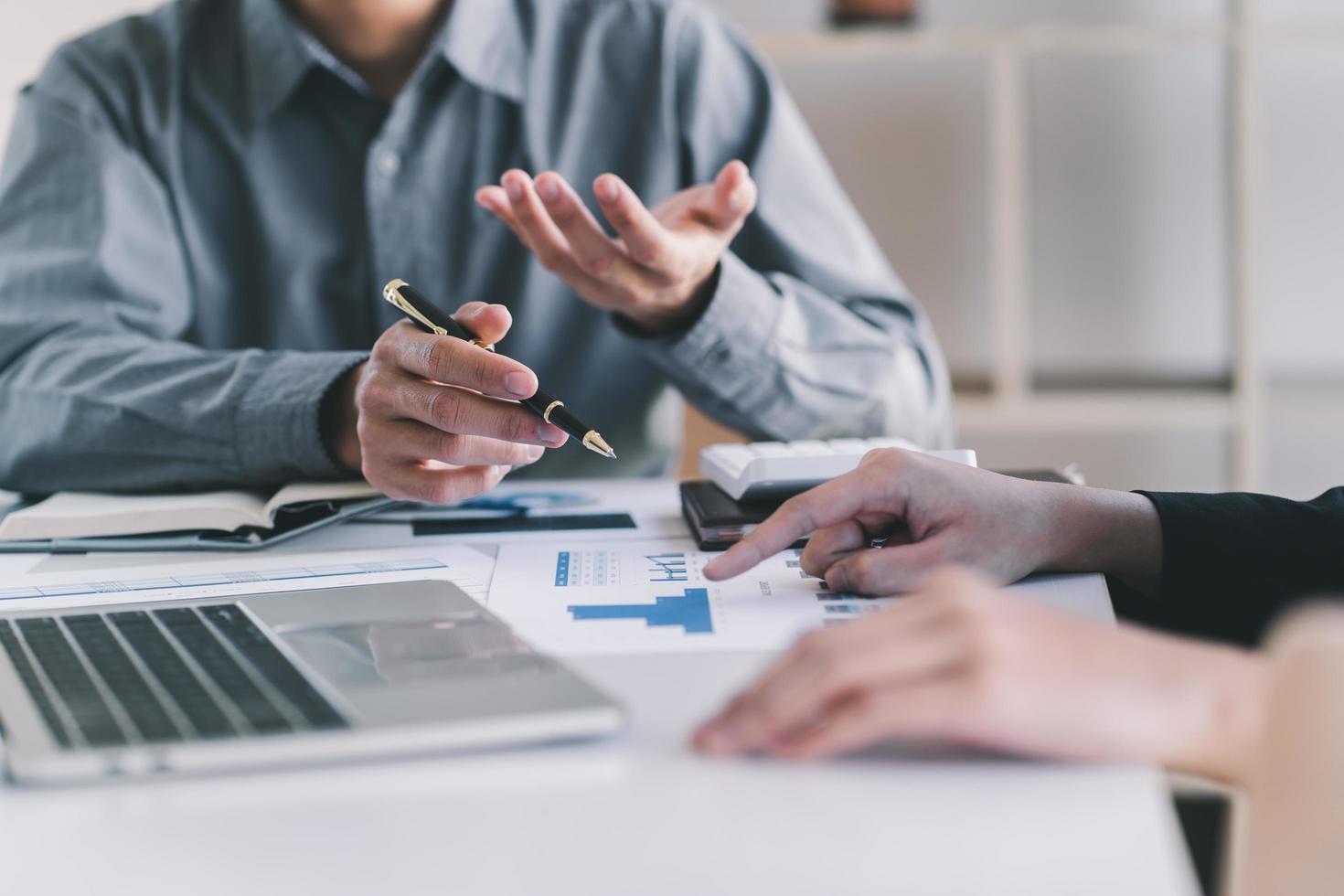 Two colleagues discussing data with document data on desk table. Close up business people meeting to discuss the situation on the market. photo