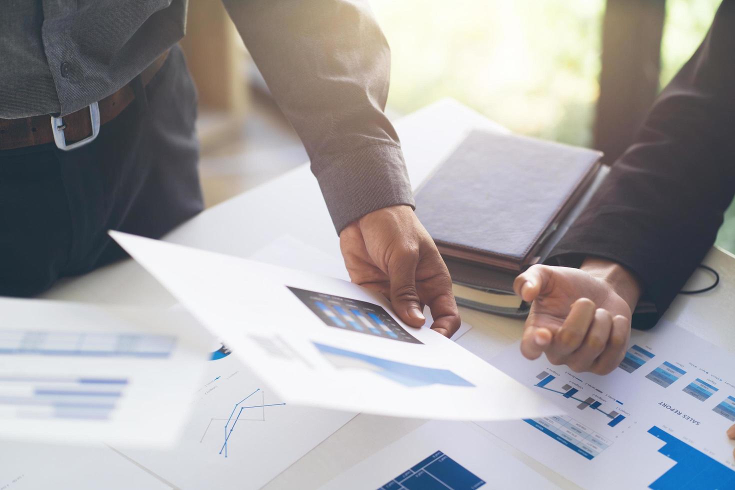 Close up hands of two colleagues discussing with document data and calculator on desk table. Close up business team analysis and strategy concept. photo