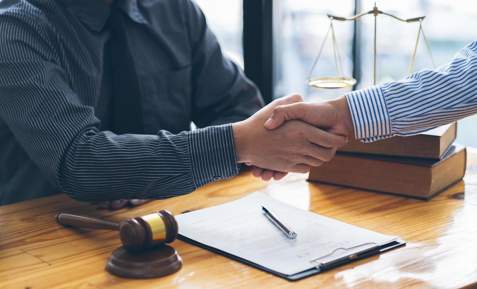 Good service cooperation of Consultation between a male lawyer and business woman customer, Handshake after good deal agreement, Law and Legal concept. photo