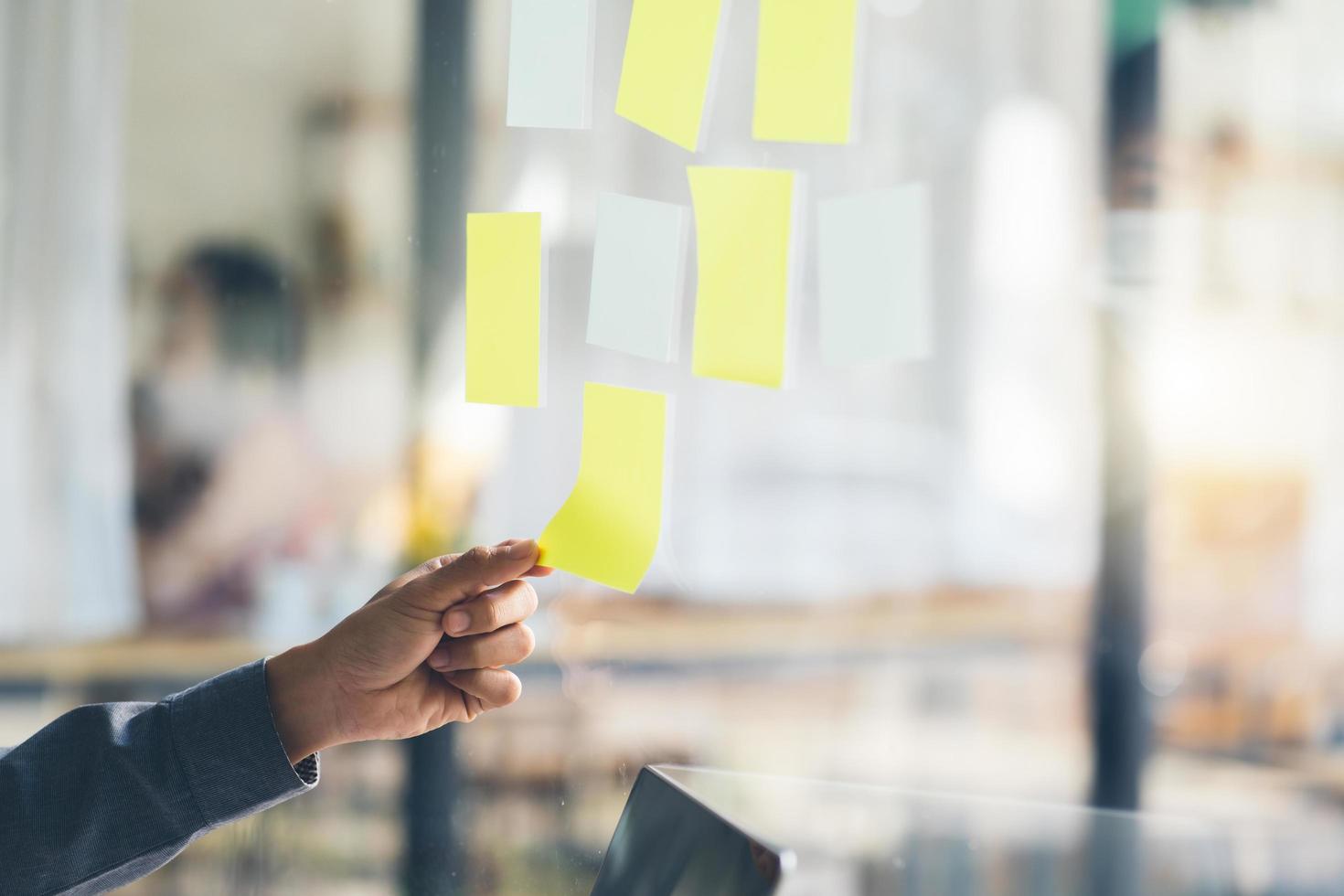 Business people meeting at office and use post it notes to share idea. Brainstorming concept. Sticky note on glass wall. photo