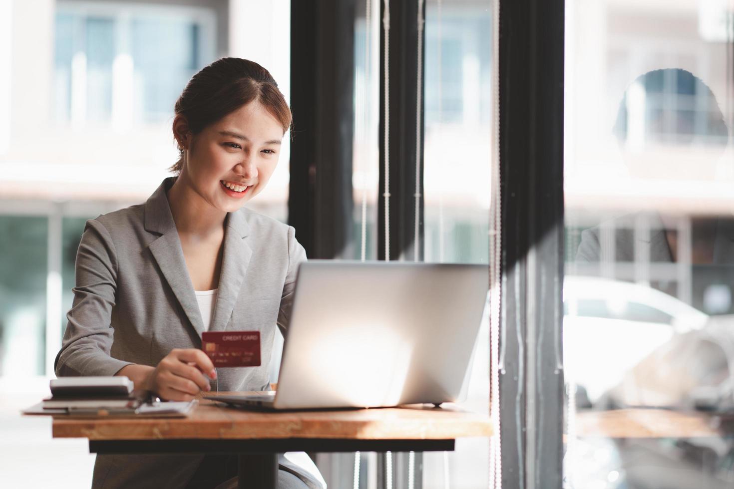 Asian woman shopping in Internet making instant Payment Transaction at Computer using Credit Card. photo